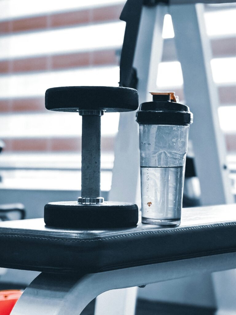 upholstery 1 Close-up of dumbbell and water bottle on a gym bench, emphasizing fitness routine.
